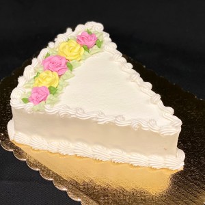 Wedge shaped frosted cake with flowers