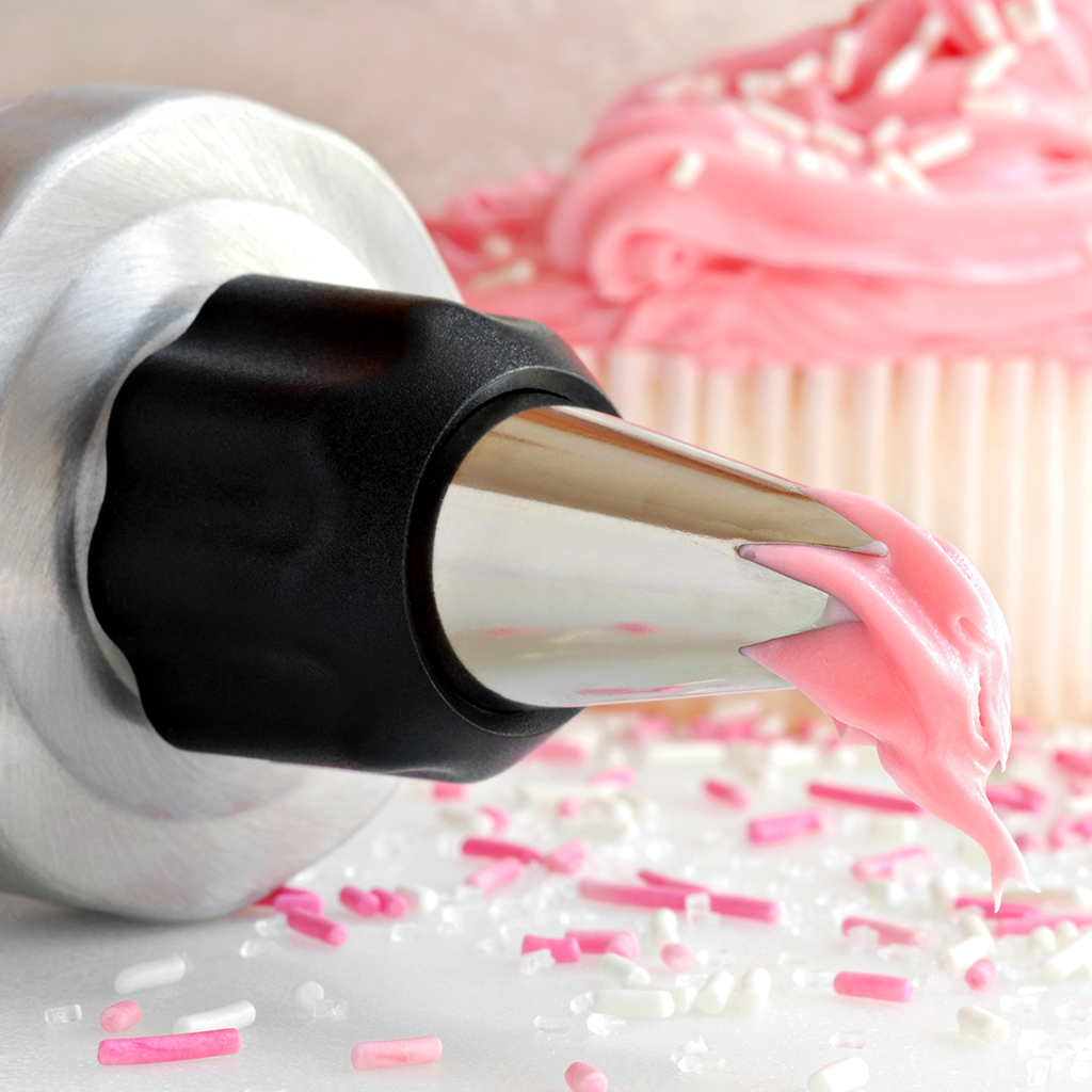 Close up of a cake decorating tip with pink frosting
